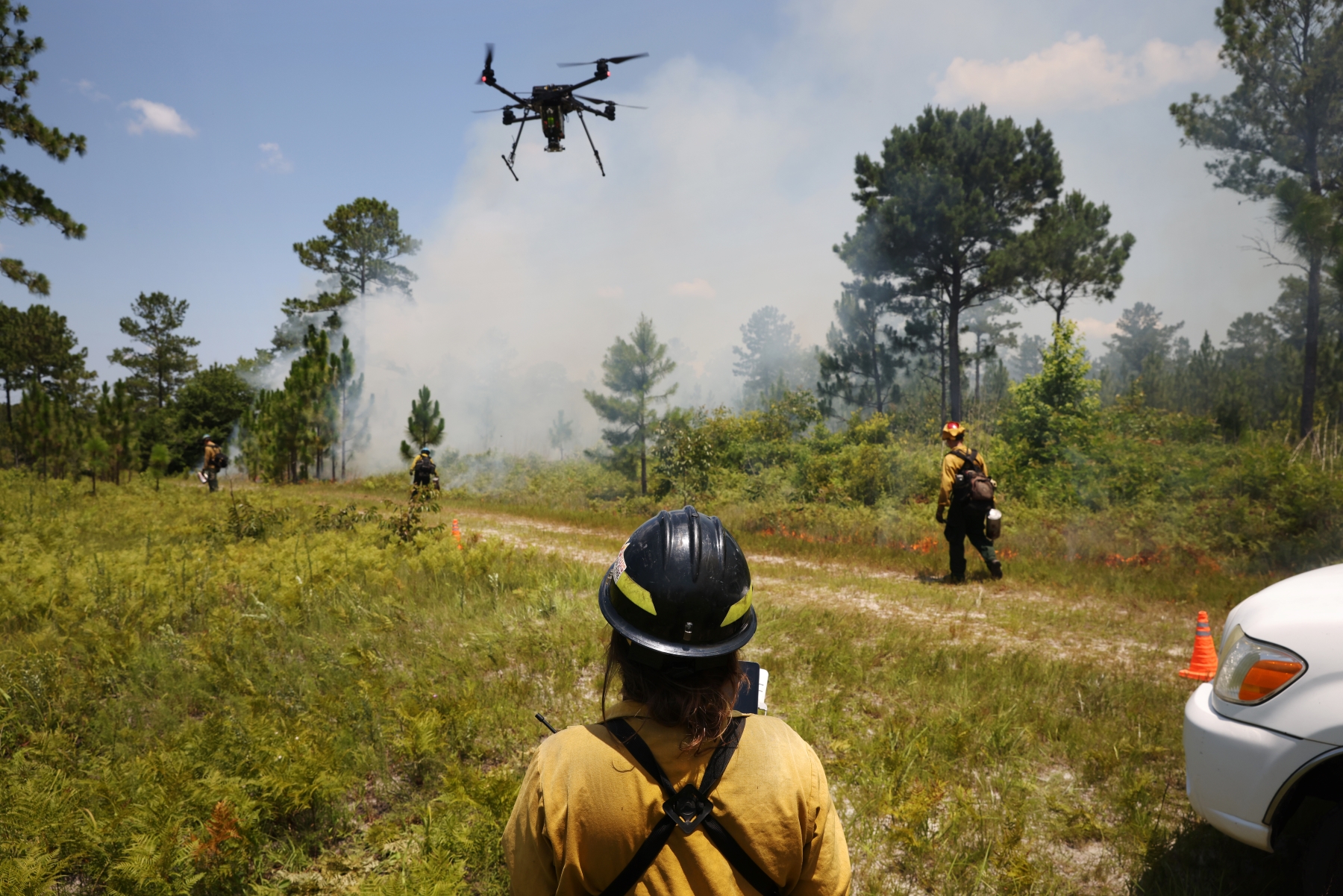 A fire crew member operates an aerial ignition drone.