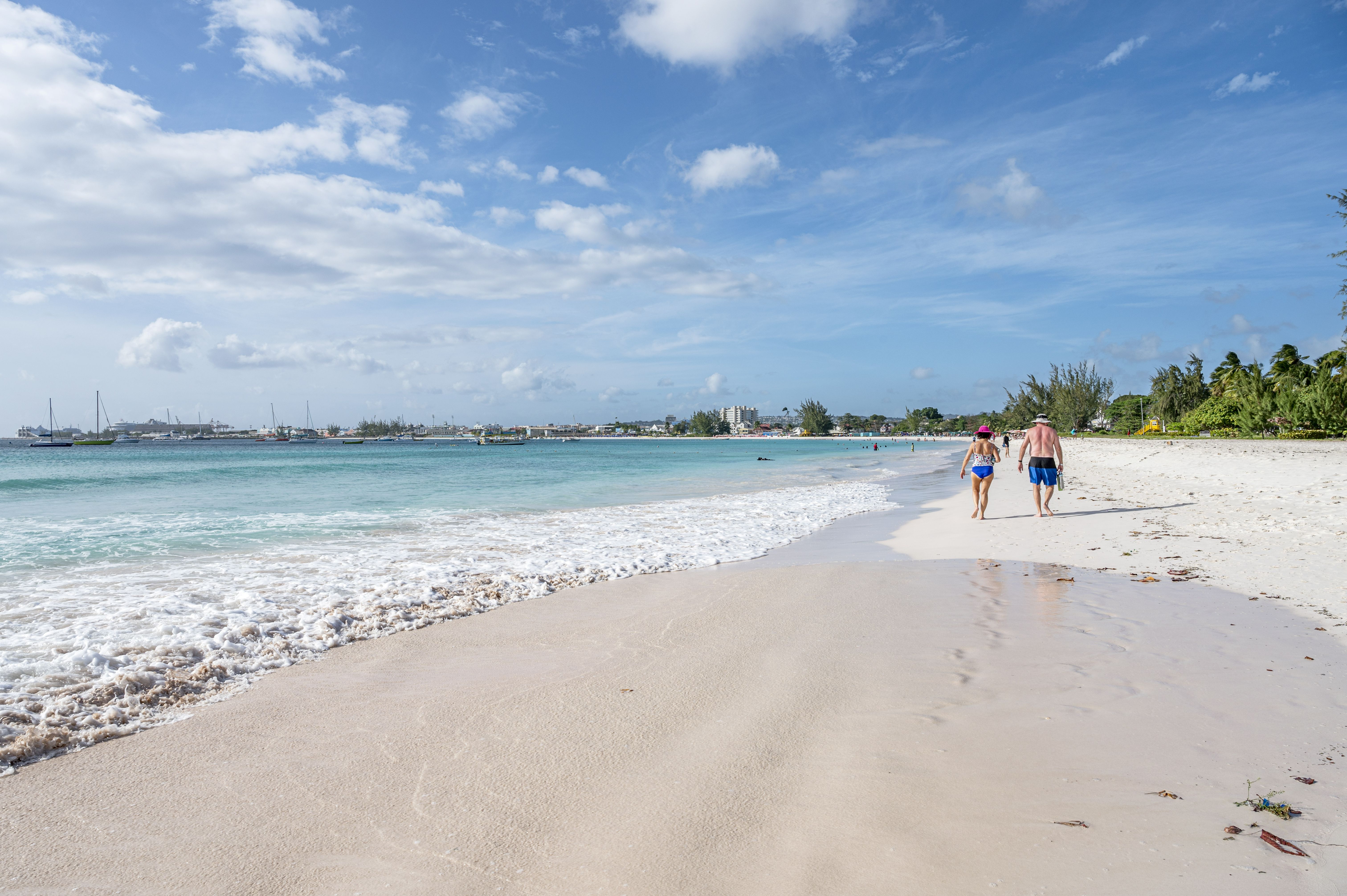 A couple walking on a beach.