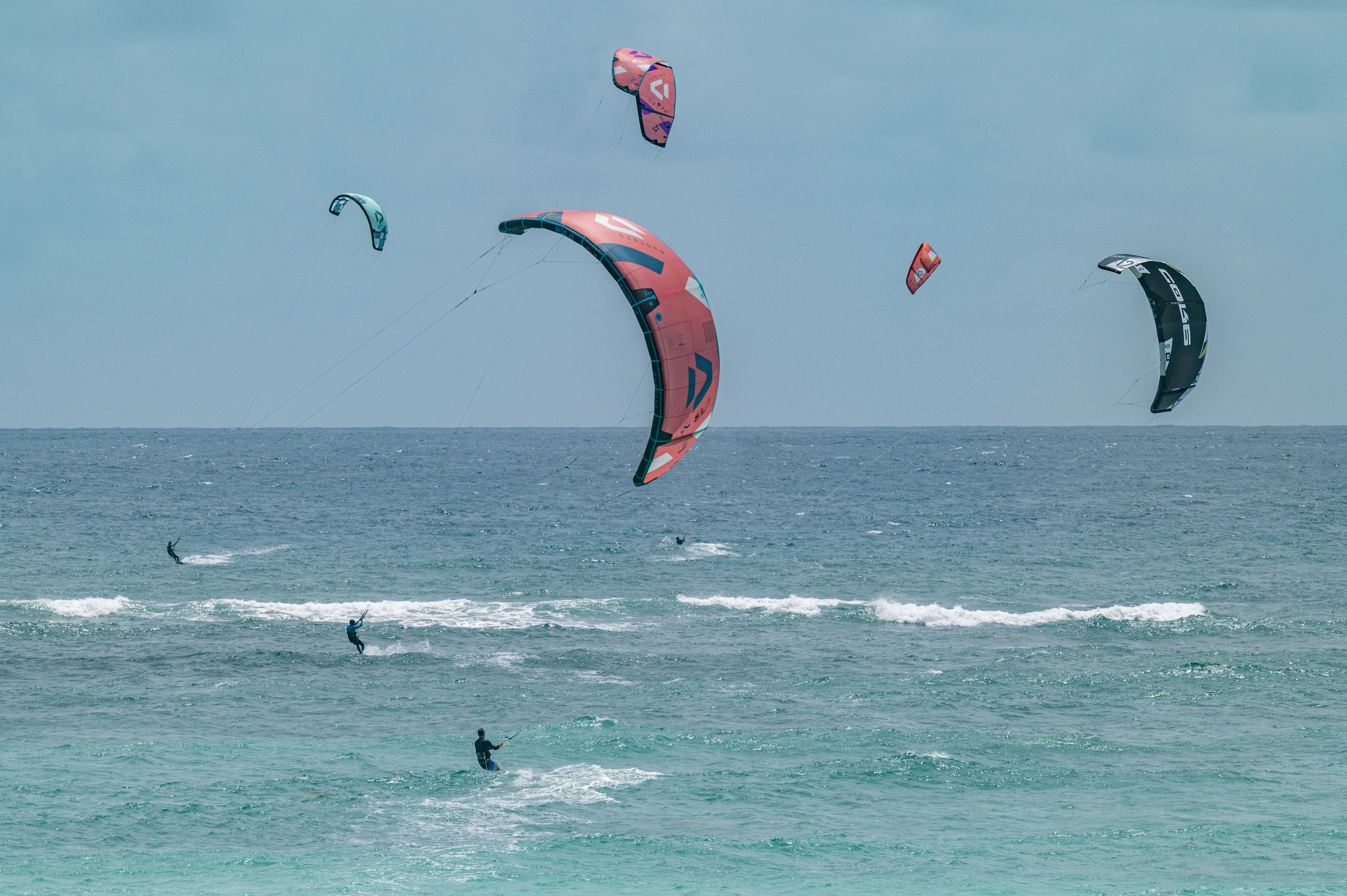 Three kite surfers out on the water.
