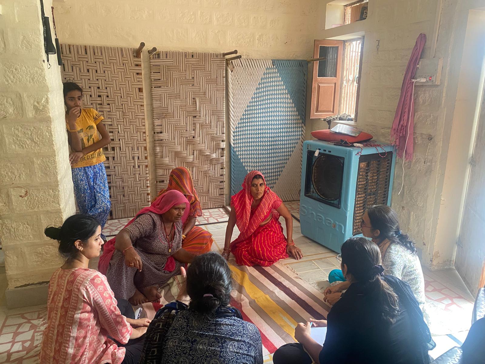 A group of women sitting on the floor talking.