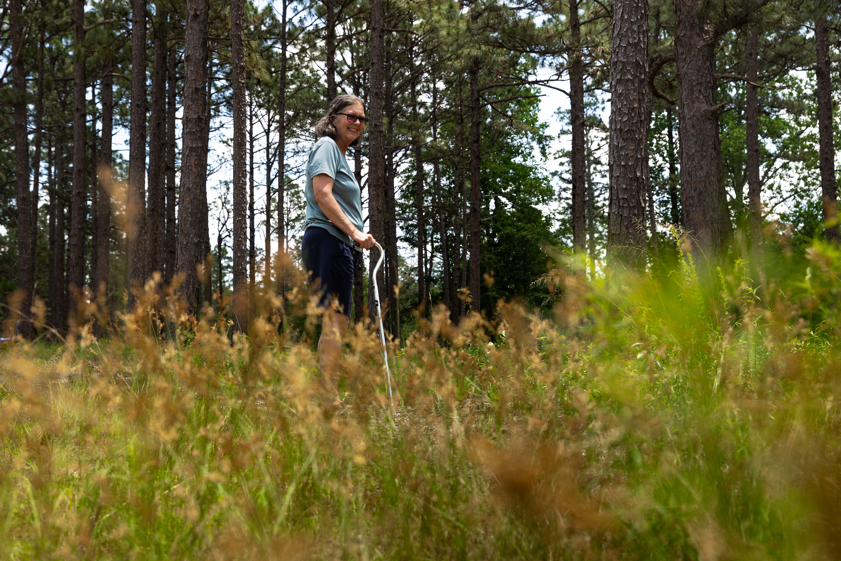 Woman poses in forest for photo.