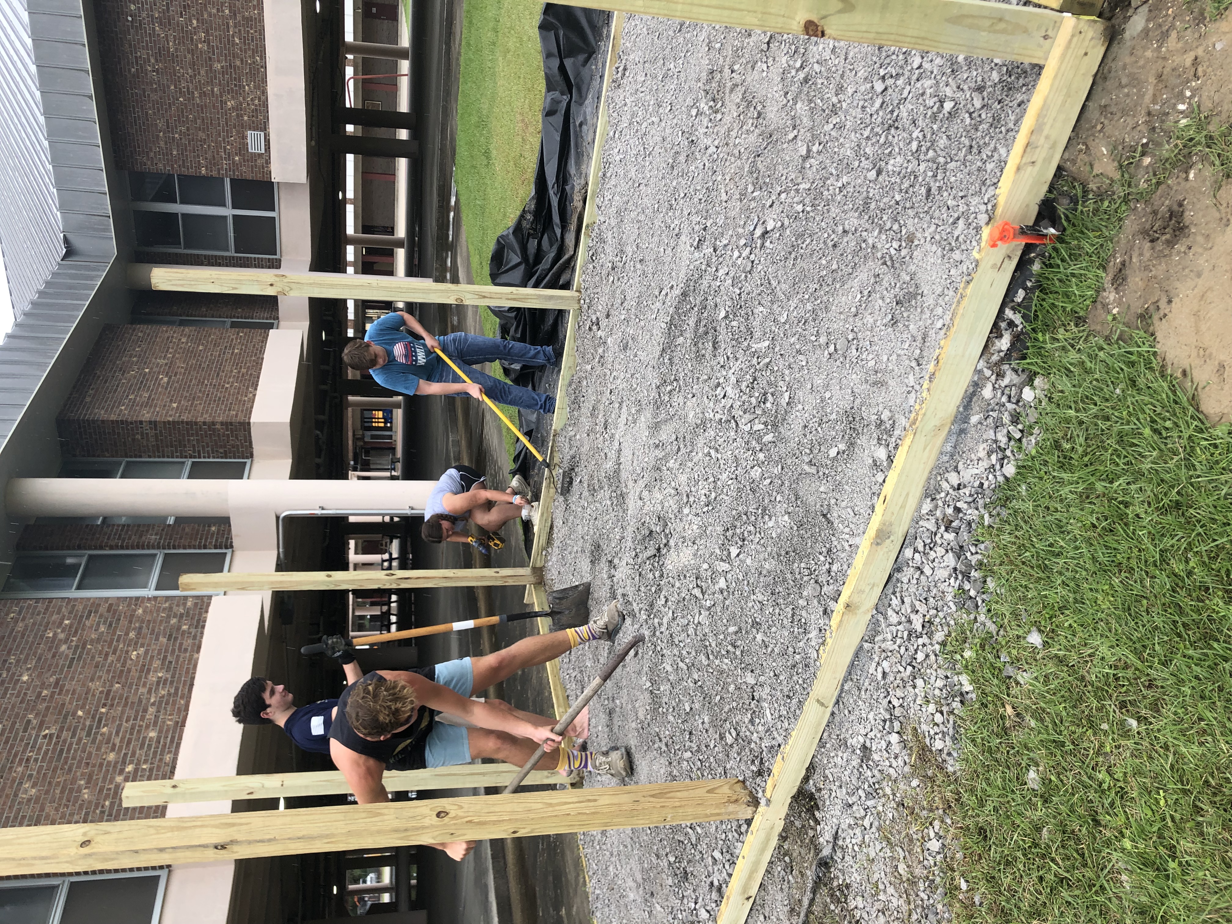 Two people help to build a wooden structure.