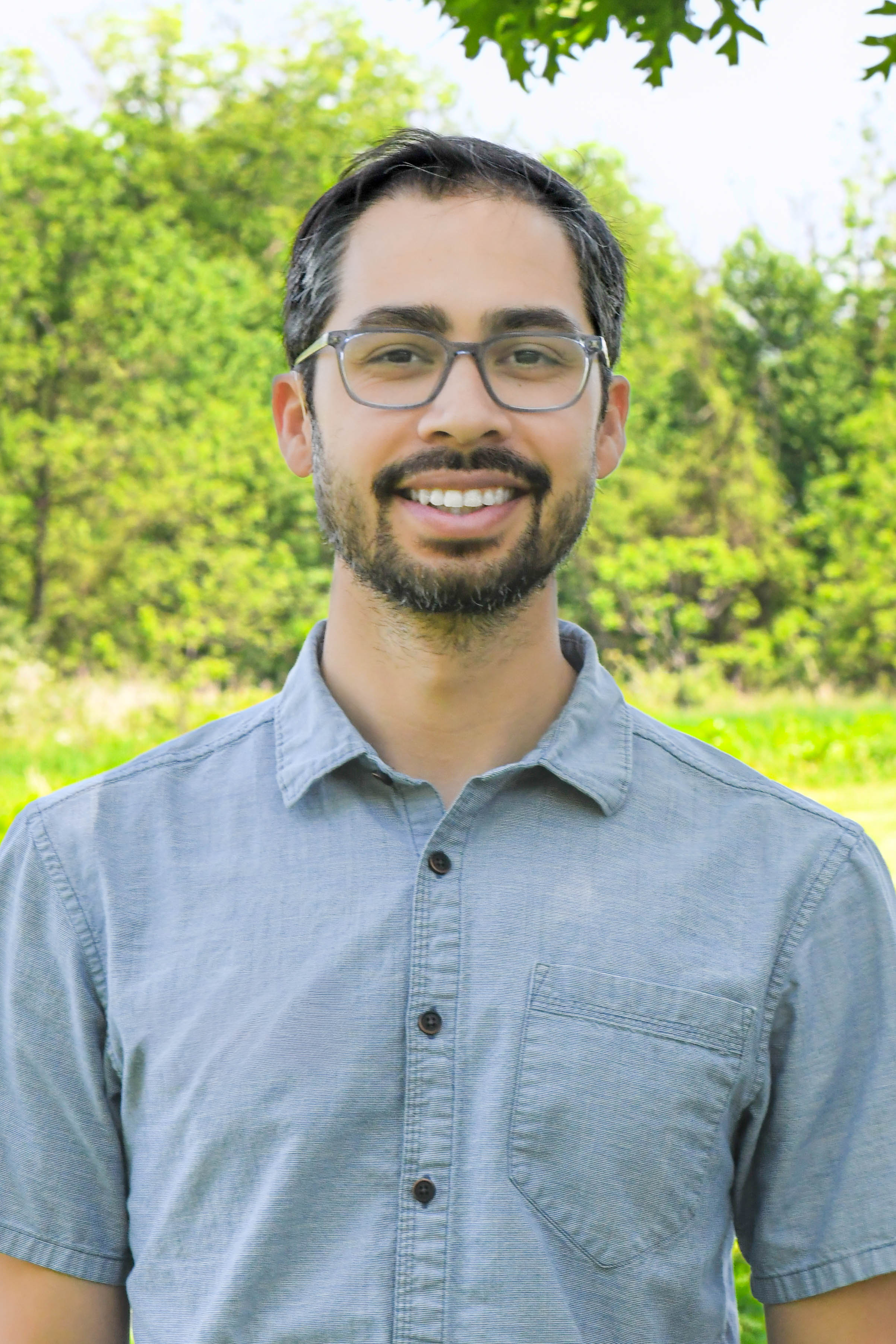 A headshot of Will Helt in front of a marsh.