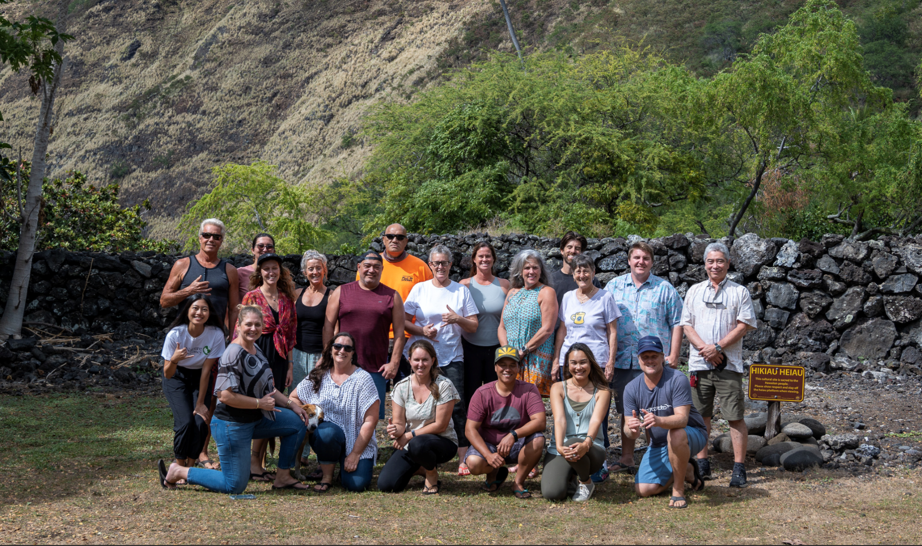 Group photo of 20 Kapukapu ʻOhana partners in front of  Hikiau Heiau.
