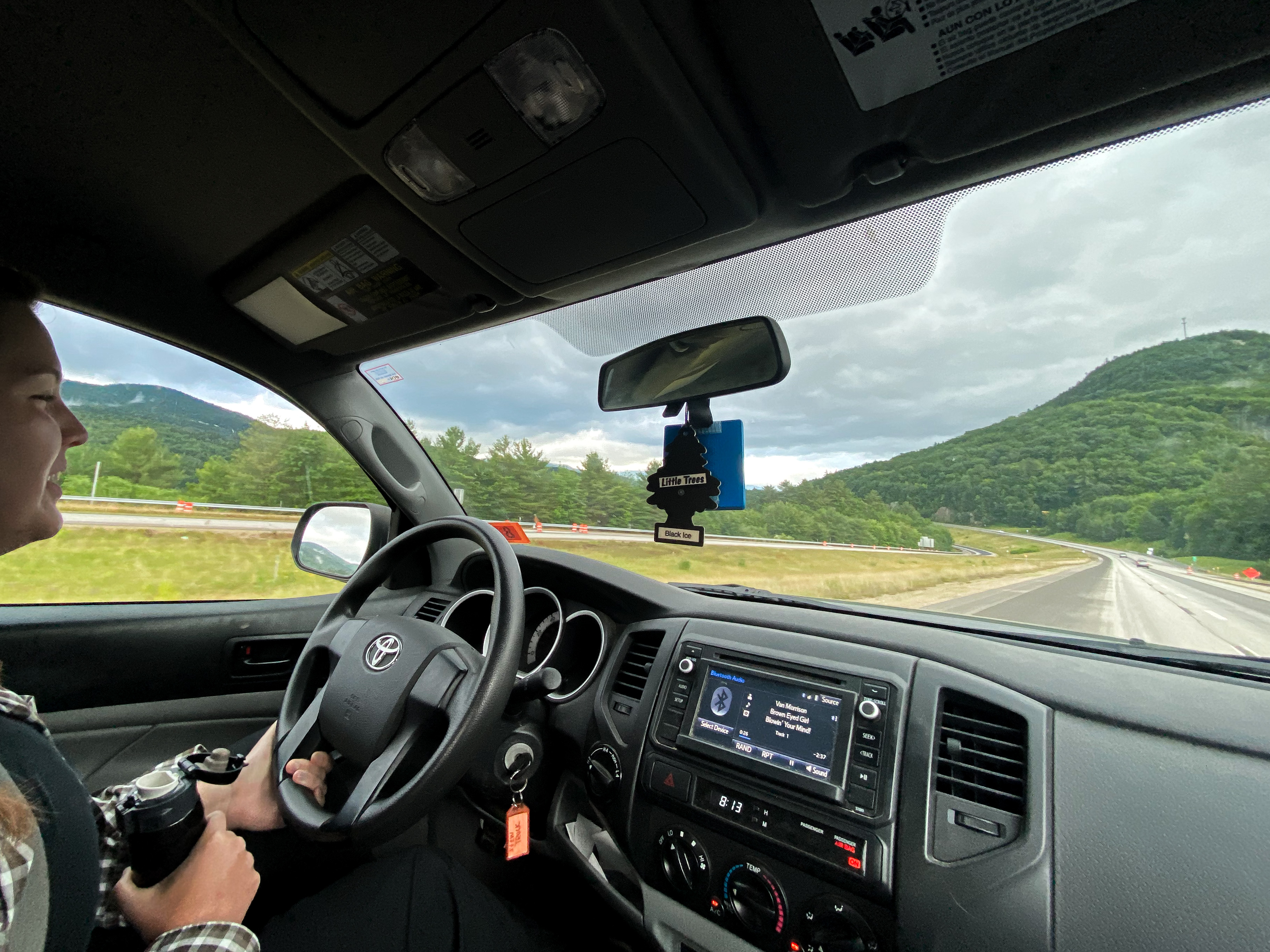 View taken from inside a car of a woman driving.