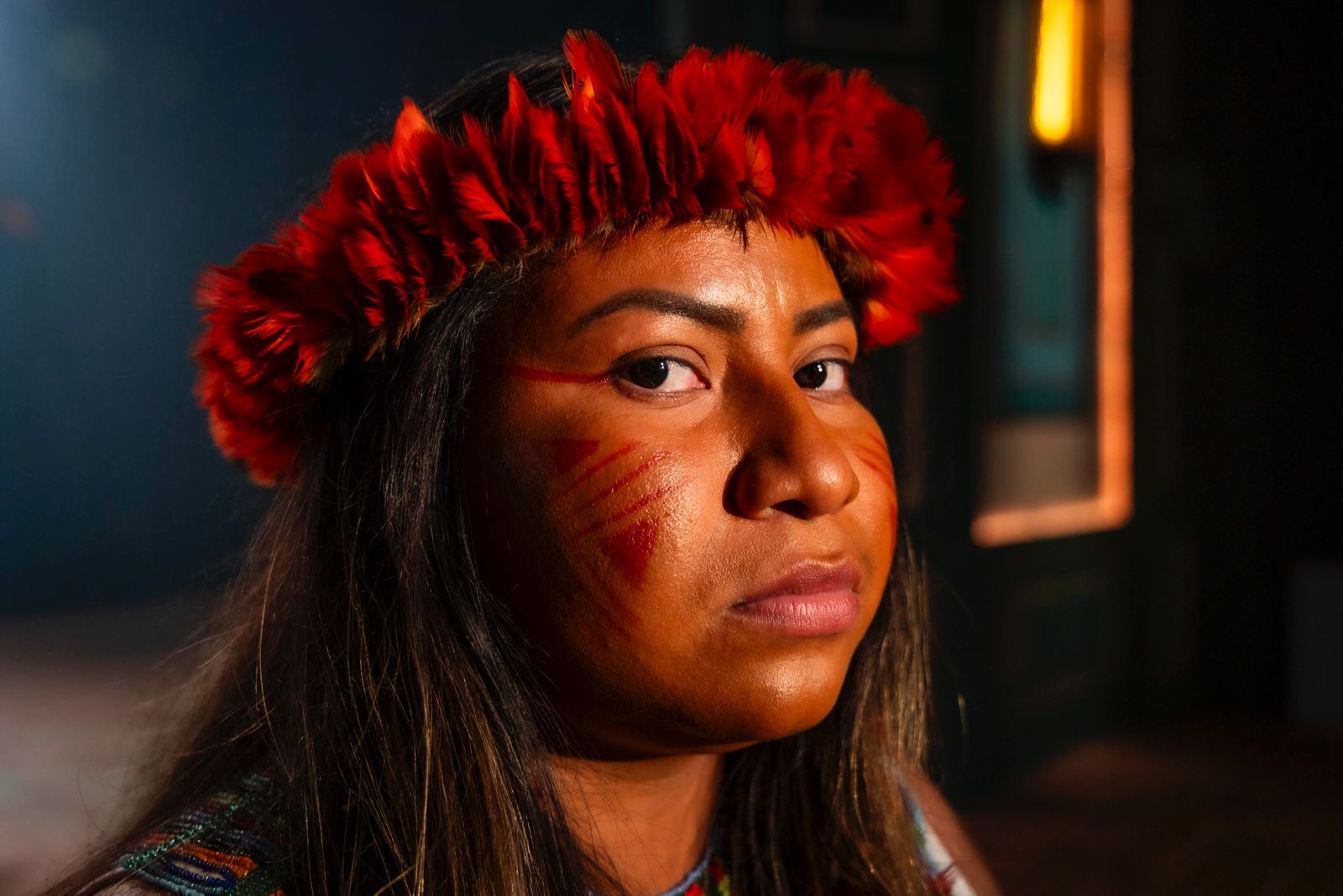 Portrait of Luene Karipuna, wearing a traditional crown of red flowers. 