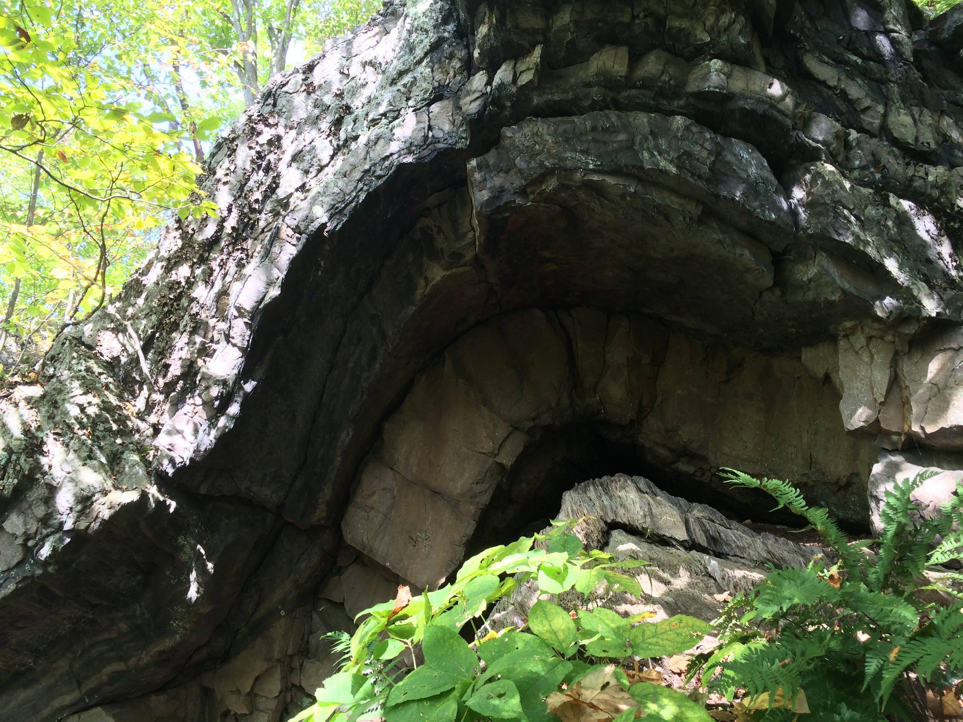 An arched rock formation leading into a cave under the arch.