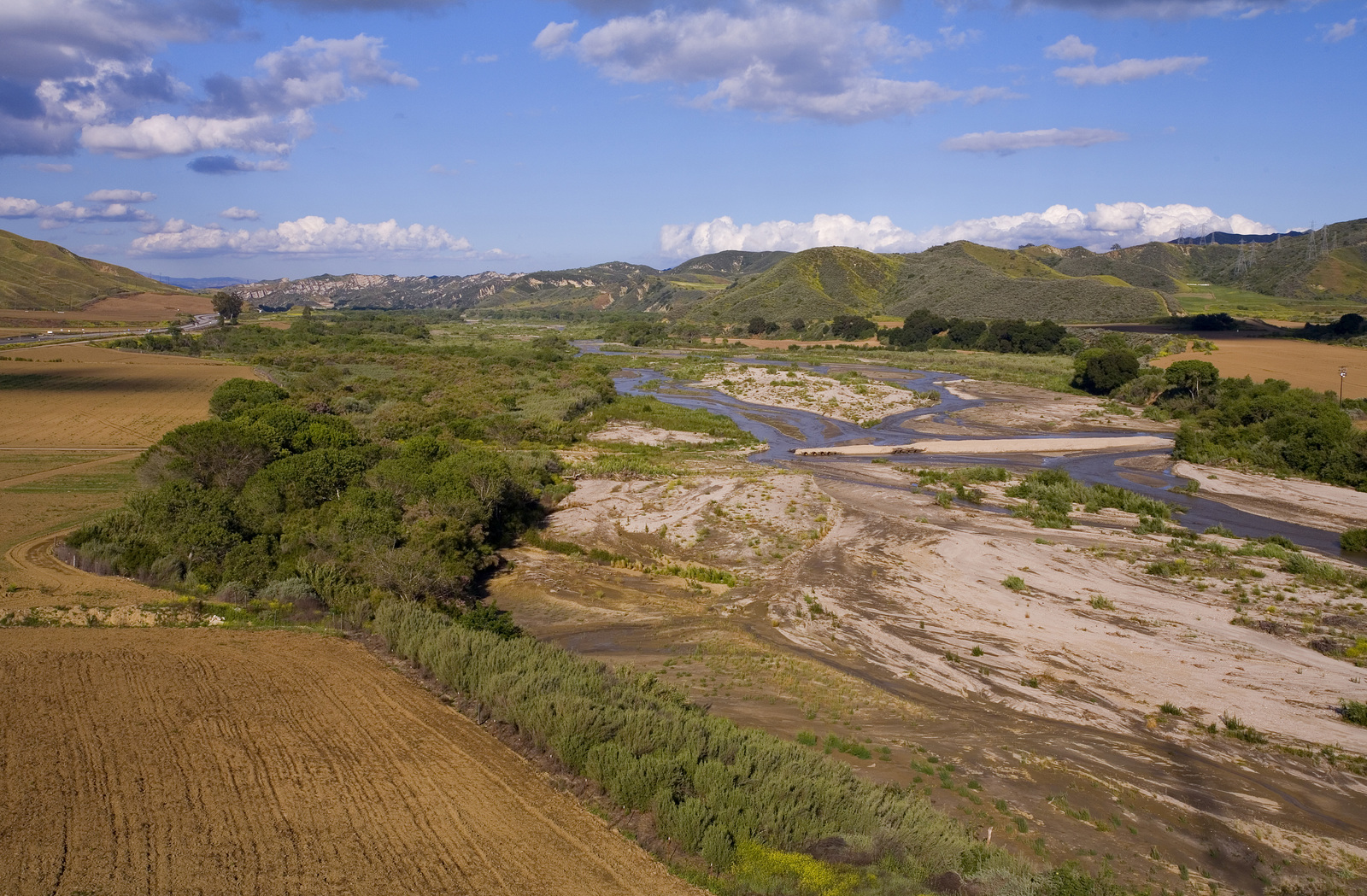 A meandering river with sandy banks in a broad valley.