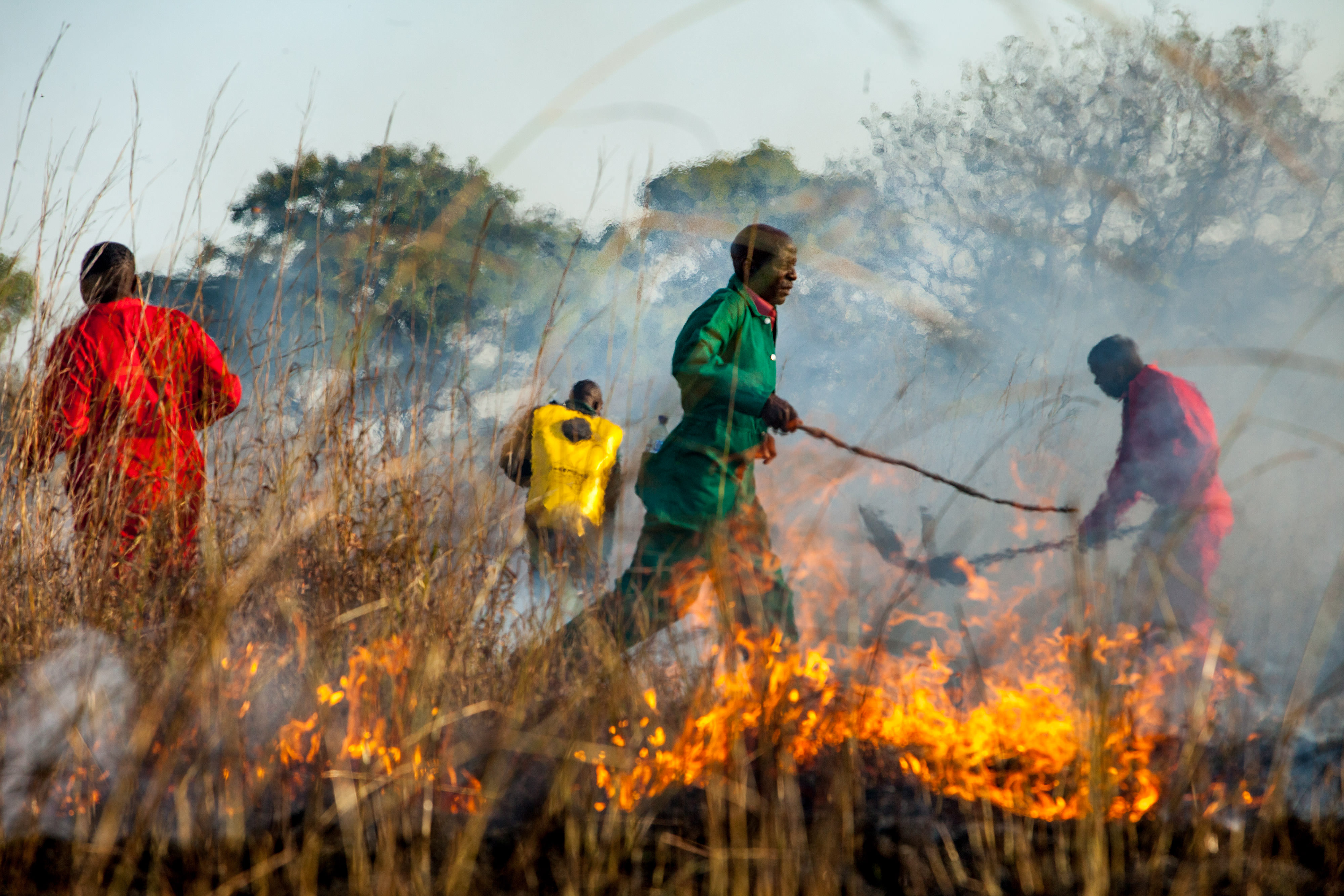 A fire training participant runs behind a fire line 